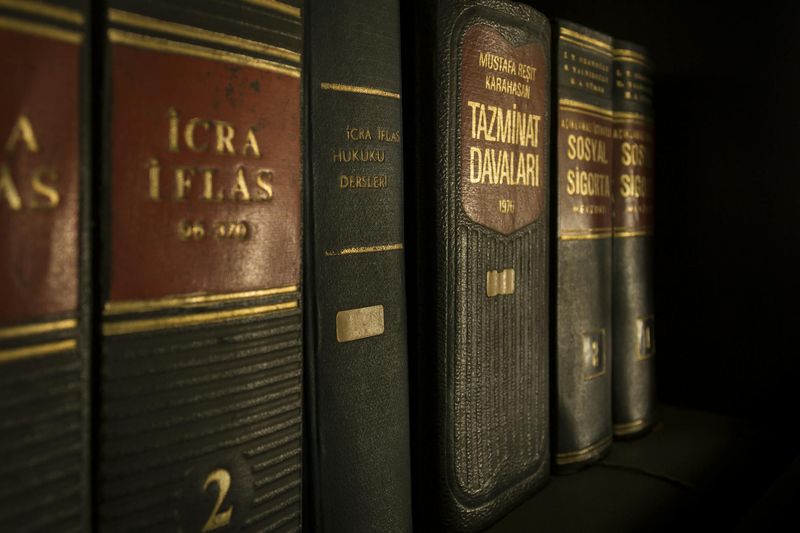 Livros de direito e regulamentação em prateleira de biblioteca jurídica, ilustrando contexto de esclerose múltipla relacionada à isenção do IR pela Lei 7.713/88.